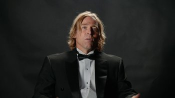 Movie still from “Jackass Forever” (2022), directed by Jeff Tremaine – A man wearing a tuxedo and a bow tie; Close Up shot, Low angle