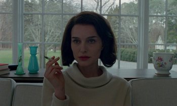 Movie still from “Jackie” (2016), directed by Pablo Larraín – A woman holding a cigarette in her hand; Close Up shot, Over the shoulder angle