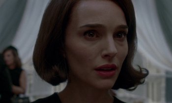 Movie still from “Jackie” (2016), directed by Pablo Larraín – A person with short brown hair; Close Up shot, Over the shoulder angle