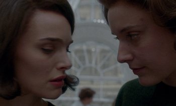 Movie still from “Jackie” (2016), directed by Pablo Larraín – A man and a woman face to face in front of a building; Close Up shot, Over the shoulder angle