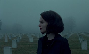 Movie still from “Jackie” (2016), directed by Pablo Larraín – A woman standing in front of a field of tombstones; Close Up shot, Over the shoulder angle