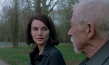 Movie still from “Jackie” (2016), directed by Pablo Larraín – A man and a woman standing next to each other in a field; Close Up shot, Over the shoulder angle