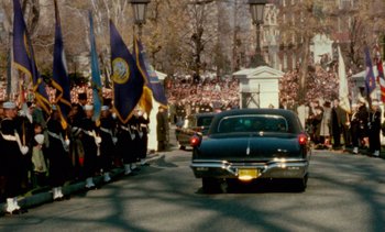 Movie still from “Jackie” (2016), directed by Pablo Larraín – A car driving down a street next to a crowd of people; Extreme Wide shot, High angle