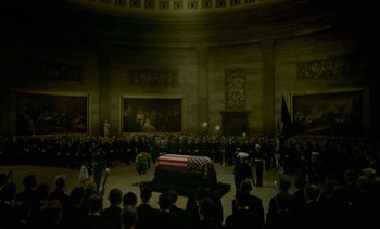 Movie still from “Jackie” (2016), directed by Pablo Larraín – A large crowd of people watching an american flag draped casket; Extreme Wide shot, High angle