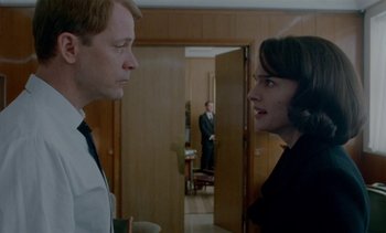 Movie still from “Jackie” (2016), directed by Pablo Larraín – A man and a woman standing in front of each other in a room; Medium shot, Over the shoulder angle