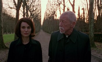 Movie still from “Jackie” (2016), directed by Pablo Larraín – A man and a woman standing next to each other on a dirt road; Medium shot, Over the shoulder angle