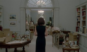 Movie still from “Jackie” (2016), directed by Pablo Larraín – A woman standing in front of a mirror in a living room; Wide shot, Over the shoulder angle