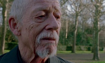 Movie still from “Jackie” (2016), directed by Pablo Larraín – An old man with a beard is looking into the distance; Close Up shot, Low angle