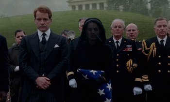 Movie still from “Jackie” (2016), directed by Pablo Larraín – A group of people standing next to each other in a field; Medium shot, Over the shoulder angle