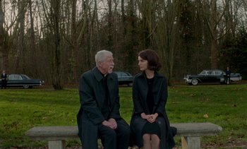 Movie still from “Jackie” (2016), directed by Pablo Larraín – An older man and a younger woman sitting on a park bench; Wide shot, Over the shoulder angle
