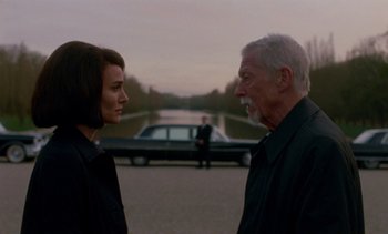 Movie still from “Jackie” (2016), directed by Pablo Larraín – A man and a woman standing next to each other on the street; Medium shot, Over the shoulder angle