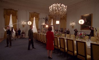 Movie still from “Jackie” (2016), directed by Pablo Larraín – People standing in front of a long dining room table; Wide shot, Low angle