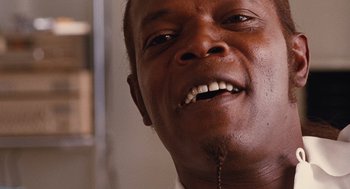 Movie still from “Jackie Brown” (1997), directed by Quentin Tarantino – A man's face with white teeth; Extreme Close Up shot, Low angle