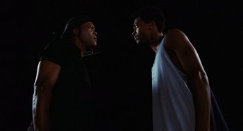 Movie still from “Jackie Brown” (1997), directed by Quentin Tarantino – Two young men standing next to each other in the dark; Medium shot, Low angle