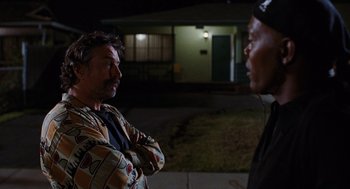 Movie still from “Jackie Brown” (1997), directed by Quentin Tarantino – Two men standing in front of a building at night; Medium shot, Over the shoulder angle