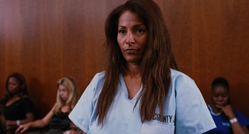 Movie still from “Jackie Brown” (1997), directed by Quentin Tarantino – A woman with long brown hair in a court room; Close Up shot, Low angle