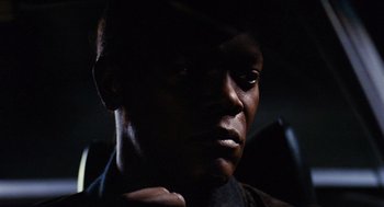 Movie still from “Jackie Brown” (1997), directed by Quentin Tarantino – A man's face in the dark; Close Up shot, Over the shoulder angle