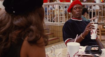 Movie still from “Jackie Brown” (1997), directed by Quentin Tarantino – A man and a woman are sitting at a table; Medium shot, Over the shoulder angle