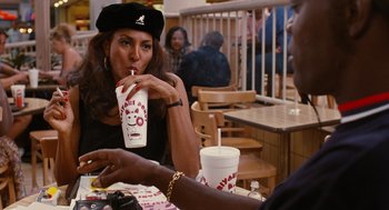 Movie still from “Jackie Brown” (1997), directed by Quentin Tarantino – Two people sitting at a table with a drink; Medium shot, High angle