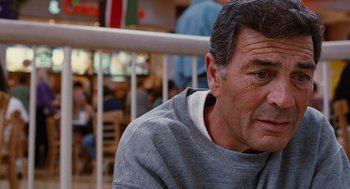 Movie still from “Jackie Brown” (1997), directed by Quentin Tarantino – An older man sitting in front of a bunch of people; Close Up shot, Over the shoulder angle