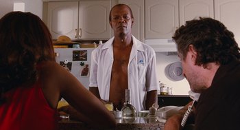 Movie still from “Jackie Brown” (1997), directed by Quentin Tarantino – A man standing in front of a kitchen counter; Medium shot, Over the shoulder angle