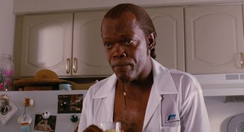 Movie still from “Jackie Brown” (1997), directed by Quentin Tarantino – A man in a white shirt is holding a drink; Close Up shot, Low angle