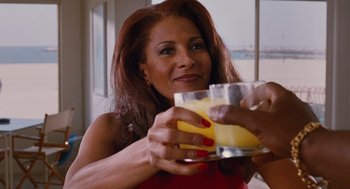 Movie still from “Jackie Brown” (1997), directed by Quentin Tarantino – A woman is holding a glass of orange juice; Close Up shot, Over the shoulder angle
