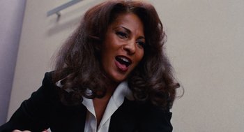Movie still from “Jackie Brown” (1997), directed by Quentin Tarantino – A person wearing a suit and tie; Close Up shot, Low angle