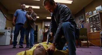 Movie still from “Jackie Brown” (1997), directed by Quentin Tarantino – A man in a yellow shirt is getting a haircut; Medium shot, Low angle