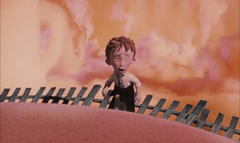 Movie still from “James and the Giant Peach” (1996), directed by Henry Selick – A cartoon of a man standing on top of a wooden fence; Wide shot, Low angle