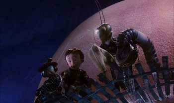 Movie still from “James and the Giant Peach” (1996), directed by Henry Selick – A group of puppets sitting on top of a platform; Medium shot, Low angle