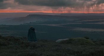 Movie still from “Jane Eyre” (2011), directed by Cary Joji Fukunaga – A person standing on top of a grass covered hill; Extreme Wide shot, High angle