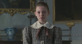 Movie still from “Jane Eyre” (2011), directed by Cary Joji Fukunaga – A young girl wearing a dress and a bow tie; Medium shot, Low angle