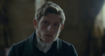 Movie still from “Jane Eyre” (2011), directed by Cary Joji Fukunaga – A young man with long blonde hair wearing a white shirt and a black jacket; Close Up shot, Over the shoulder angle
