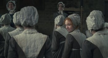 Movie still from “Jane Eyre” (2011), directed by Cary Joji Fukunaga – A group of women in period clothing standing next to each other; Medium shot, Over the shoulder angle