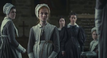 Movie still from “Jane Eyre” (2011), directed by Cary Joji Fukunaga – A group of people in a room holding a cane; Medium shot, Low angle