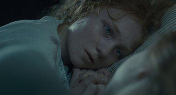 Movie still from “Jane Eyre” (2011), directed by Cary Joji Fukunaga – A young girl laying in bed with her head resting on a pillow; Close Up shot, Overhead angle