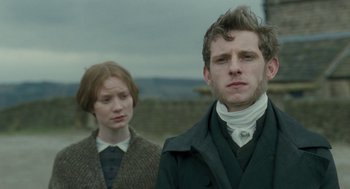 Movie still from “Jane Eyre” (2011), directed by Cary Joji Fukunaga – A man and a woman standing next to each other; Close Up shot, Low angle