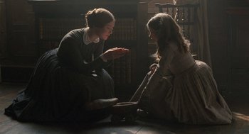 Movie still from “Jane Eyre” (2011), directed by Cary Joji Fukunaga – Two women sitting on the floor in a room; Medium shot, High angle