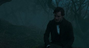Movie still from “Jane Eyre” (2011), directed by Cary Joji Fukunaga – A man sitting on the ground in the dark; Medium shot, Over the shoulder angle