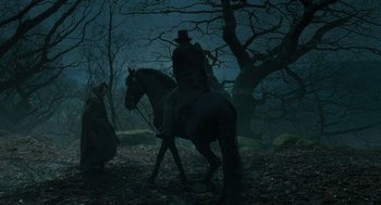 Movie still from “Jane Eyre” (2011), directed by Cary Joji Fukunaga – A man riding a horse in the woods at night; Wide shot, Low angle