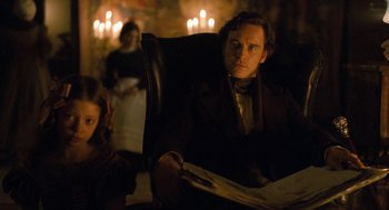 Movie still from “Jane Eyre” (2011), directed by Cary Joji Fukunaga – A man sitting in a chair next to a woman; Medium shot, Over the shoulder angle