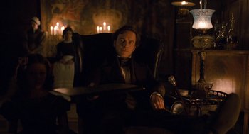 Movie still from “Jane Eyre” (2011), directed by Cary Joji Fukunaga – A man sitting in a chair in a dark room; Medium shot, High angle