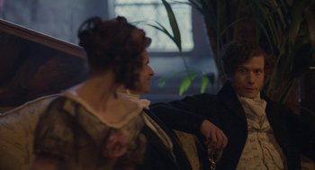 Movie still from “Jane Eyre” (2011), directed by Cary Joji Fukunaga – A man and a woman are sitting next to each other holding wine glasses; Medium shot, Over the shoulder angle