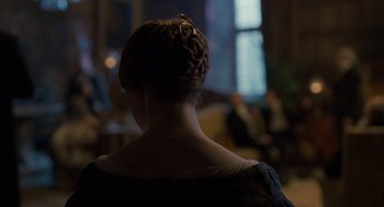 Movie still from “Jane Eyre” (2011), directed by Cary Joji Fukunaga – A woman with a braid in her hair looking out a window; Medium shot, Over the shoulder angle