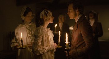 Movie still from “Jane Eyre” (2011), directed by Cary Joji Fukunaga – A man and a woman are holding lit candles; Medium shot, Over the shoulder angle