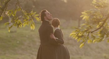 Movie still from “Jane Eyre” (2011), directed by Cary Joji Fukunaga – A man and a woman standing next to each other in a field; Medium shot, Low angle