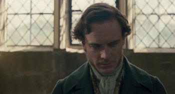 Movie still from “Jane Eyre” (2011), directed by Cary Joji Fukunaga – A person wearing a suit and a necklace; Close Up shot, Over the shoulder angle
