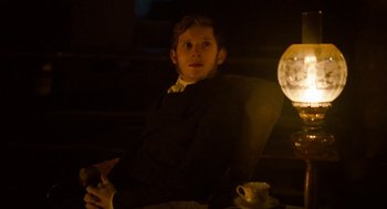 Movie still from “Jane Eyre” (2011), directed by Cary Joji Fukunaga – A man sitting in a chair in a dimly - lit room; Medium shot, Over the shoulder angle