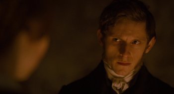 Movie still from “Jane Eyre” (2011), directed by Cary Joji Fukunaga – A man wearing a suit and a white tie; Close Up shot, Over the shoulder angle